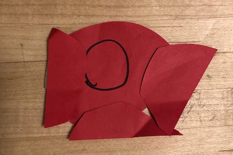 Pook in a red astronaut suit made out of a collage of red paper.